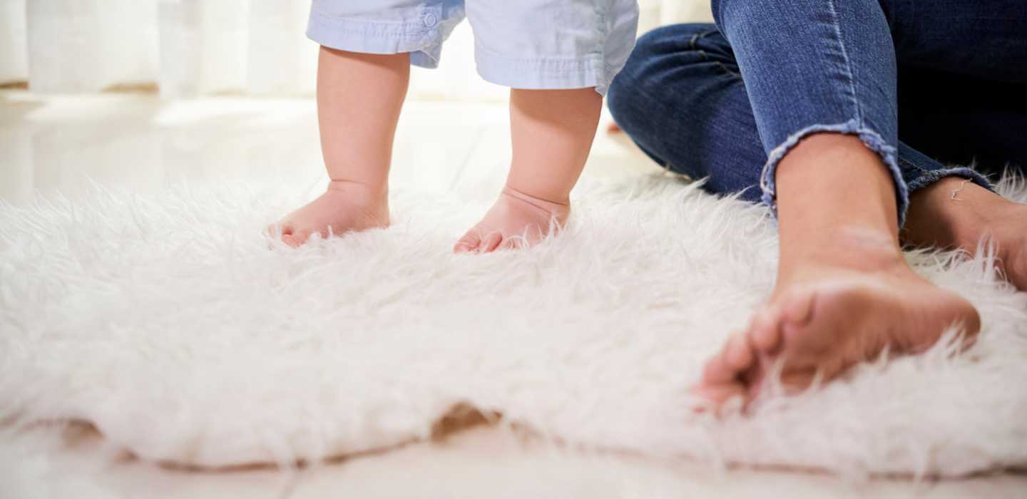Child walking on a soft furry carpet in a home